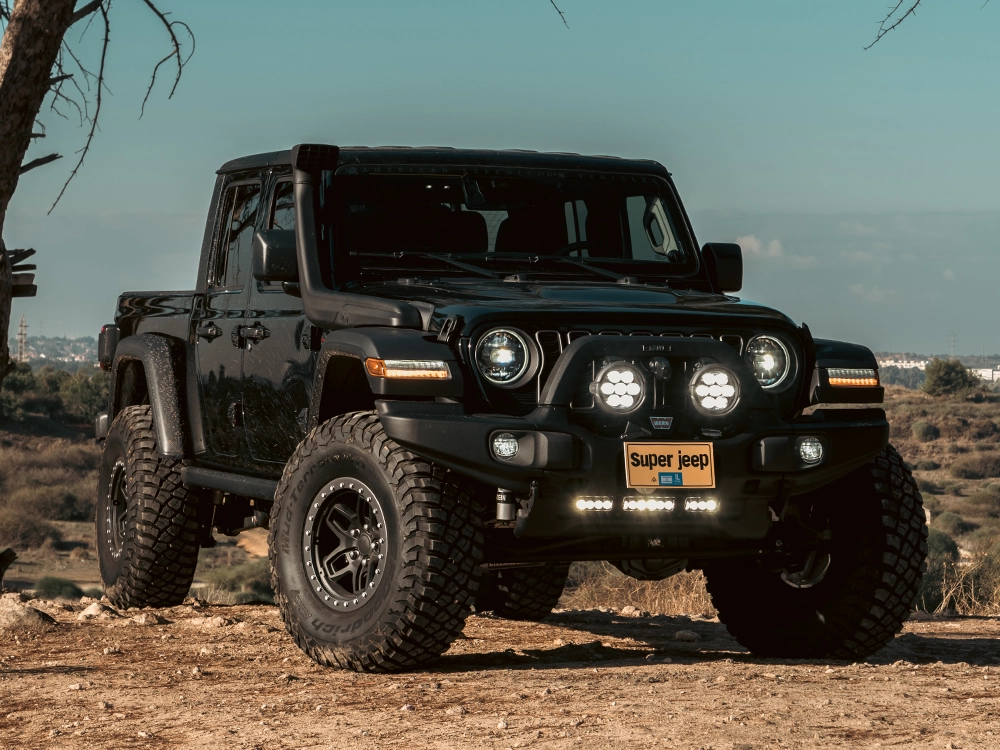 Jeep Gladiator Rubicon AEV - תקריב חזית בזווית אלכסונית, פנסי חזית וצמיגי שטח